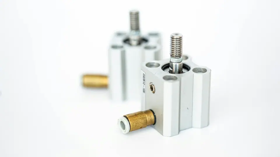 Two compact pneumatic cylinders with brass fittings