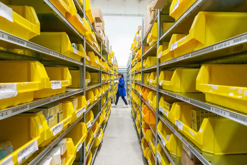 Aisle of parts shelving with yellow storage bins