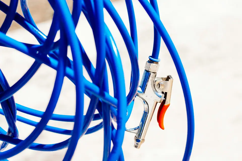 Coils of blue pneumatic tubing with an air blow gun